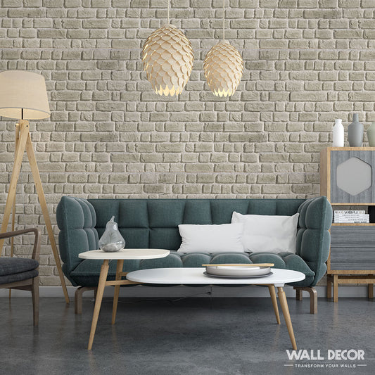 Salon moderne présentant un canapé touffeté gris, des tables blanches emboîtées et des lampes suspendues. La brique murale Panespol™ Parement Briquette Beige Titane ajoute une touche élégante, mêlant confort et élégance dans cet espace accueillant.