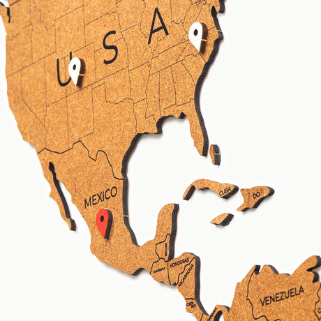 La World Map™ Carte du monde en Bois 150x90cm - Marron présente des détails sur les pays et comprend deux punaises - une blanche aux États-Unis et une rouge au Mexique - qui mettent en évidence l'Amérique du Nord, l'Amérique centrale et les Caraïbes.