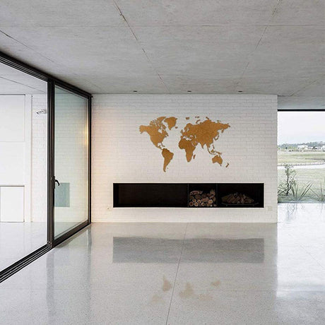 Un salon moderne avec des murs en briques blanches, un sol poli, des fenêtres en verre et l'art mural World Map™ "Carte du monde en Bois 180x108cm - Marron" crée une toile de fond minimaliste étonnante pour une esthétique propre et élégante.