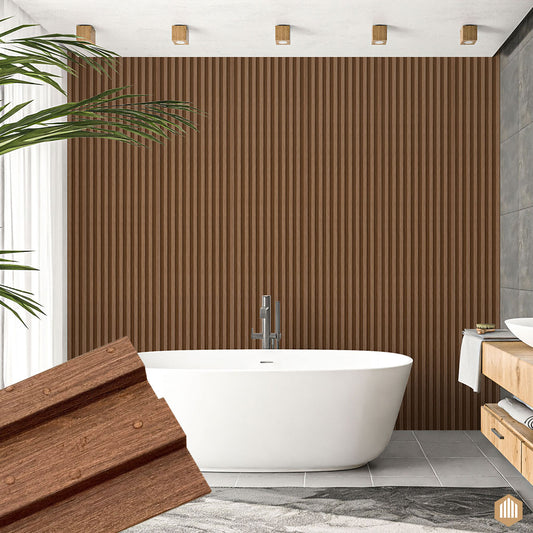 Une salle de bain moderne avec une baignoire ovale blanche, Acoupanel™ Panneau Tasseau Hydrofuge effet Chêne Brun mur d'accent, carrelage gris, meuble-lavabo en bois clair, et une plante verte partiellement visible sur la gauche.