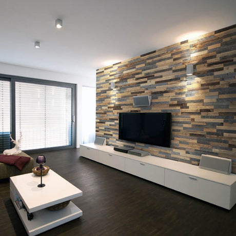 Créez un salon moderne avec Parement Bois Lamellas de Wood & Wall Decor™ - un mur d'accent en bois empilé derrière un téléviseur monté, associé à des armoires blanches, un plancher en bois foncé et de grandes fenêtres pour un look chaleureux et minimaliste.