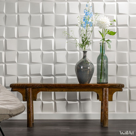 Un banc en bois avec deux vases, l'un en céramique, l'autre en verre, se trouve devant un WallArt Wall Decor© Panneau Mural 3D Oberon (boîte de 12 panneaux, 3m²). Le sol sombre et une partie d'une chaise claire sont également visibles.
