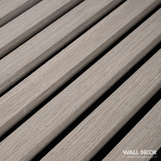 Gros plan sur Acoupanel™ Panneaux Tasseaux Acoustiques Chêne Gris - 1,28m : des lames parallèles en chêne gris clair avec une finition texturée et des espaces réguliers sur un fond noir, créant un accent mural moderne.