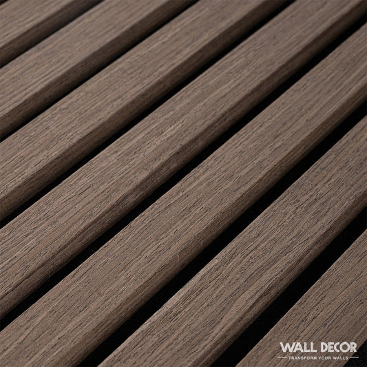 Gros plan sur Acoupanel™ Panneaux Tasseaux Acoustiques Chêne Marron (1,28m²) présentant des lattes de bois lisses et brunes disposées en diagonale sur un fond noir. Le logo Wall Decor et le slogan "Transform Your Walls" apparaissent dans le coin inférieur droit.