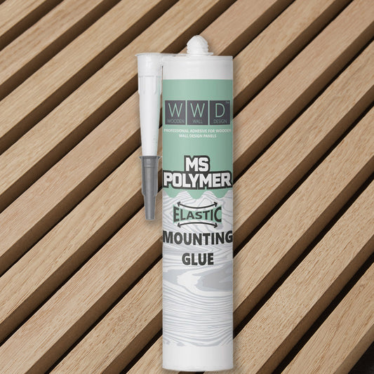 Un tube de Colle Parement Bois 290 ml (1,5 à 2 m²) de WallArt Wall Decor© muni d'une buse repose sur des lattes de bois disposées en diagonale. L'étiquette indique qu'il s'agit d'une colle professionnelle pour la pose de panneaux muraux design en bois.