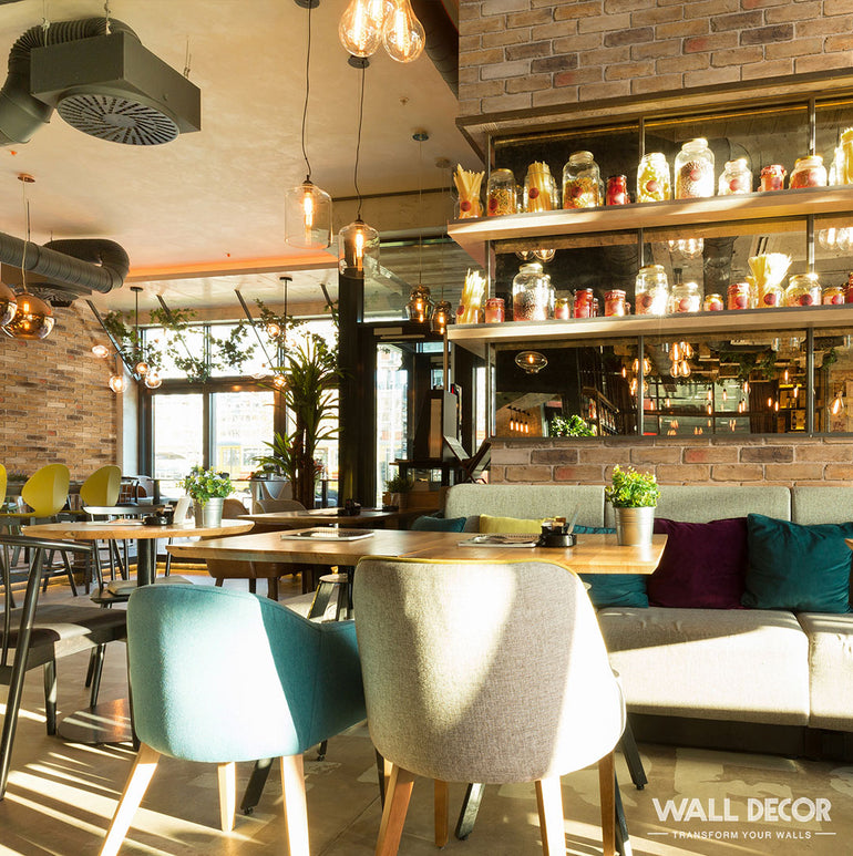 Un café confortable et ensoleillé, au décor moderne et aux chaises colorées, avec des tables en bois, des plantes en pot et des murs en Panespol™ Parement Brique Marron - English Brick ; de grandes fenêtres et des étagères avec des bocaux ajoutent du charme.