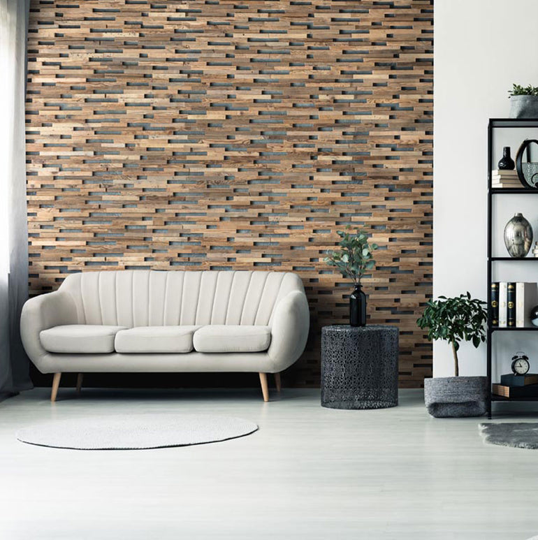 Salon moderne avec un canapé beige, un tapis rond gris, une étagère en métal noir et un mur d'accent en bandes horizontales utilisant Parement Bois Visio de Wood & Wall Decor™. Une petite table d'appoint ronde et des plantes en pot complètent le look.