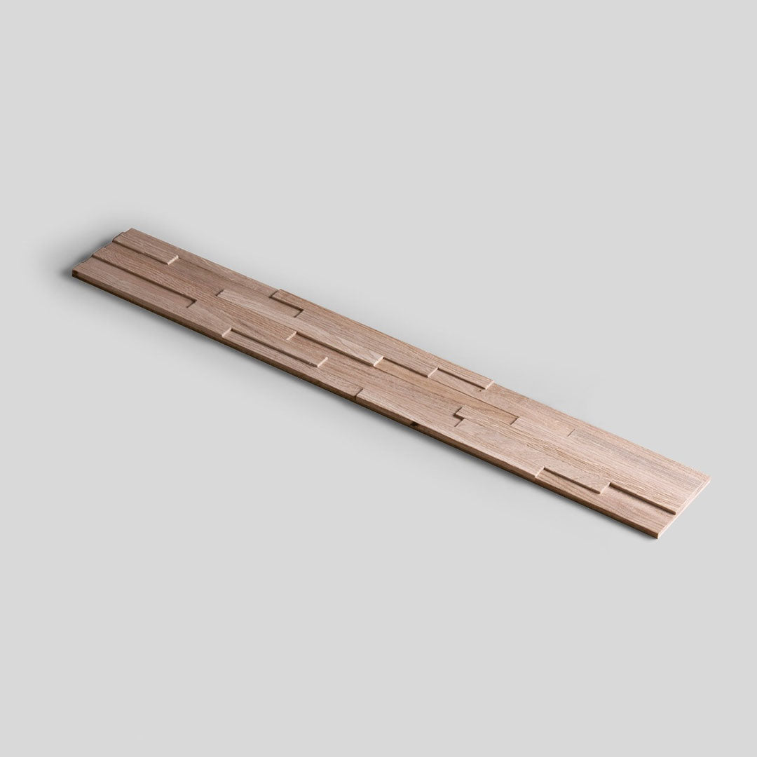 L'Échantillon Parement Bois de Wood & Wall Decor™ est une planche échantillon en bois, longue et étroite, avec un motif géométrique tridimensionnel de rectangles en relief et en creux, représenté sur un fond gris clair. Choisissez votre motif !.