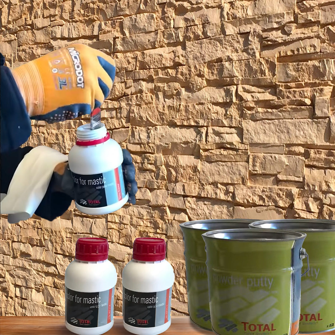Une personne portant des gants ouvre un Kit de Finition Parement Mural blanc de Covering Panels™ à côté de deux kits similaires et de deux grandes boîtes vertes de mastic en poudre, le tout posé contre un mur de pierre texturé.