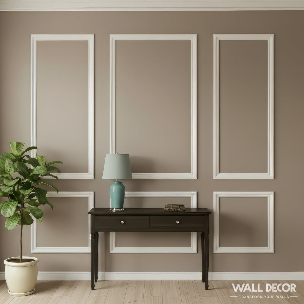 Une pièce minimaliste aux murs taupe présente le Kit Moulures Murales Alizée de MURS 3D, une table console sombre à deux tiroirs, une lampe bleu-vert, des livres empilés, une plante en pot et la mention "décoration murale" dans le coin inférieur droit.