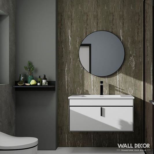 Salle de bain moderne aux murs de marbre foncé avec Panneaux SPC aspect Béton London by Murs 3D by Wall Decor, un miroir rond au-dessus d'un meuble-lavabo flottant blanc, un robinet noir, un décor avec des plantes et des bouteilles, et une partie de toilette blanche visible. Marque Wall Decor dans un coin.