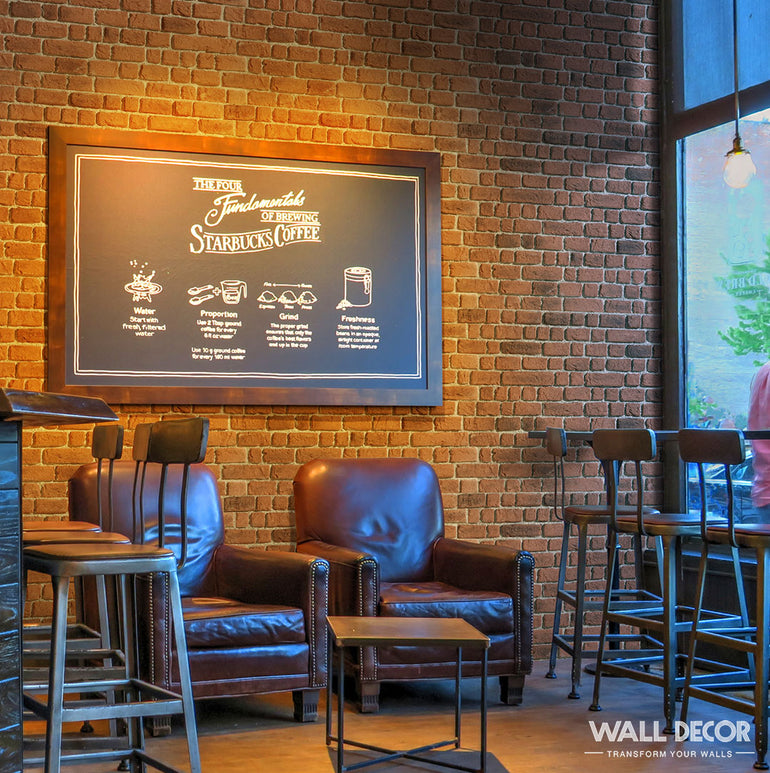 Café confortable mettant en vedette Panespol™ Parement Briquette Rouge - Wall Brick, avec des fauteuils en cuir, des tables en bois, des tabourets hauts et un grand menu sur tableau noir. La lumière du soleil à travers la fenêtre crée une atmosphère chaleureuse et accueillante.