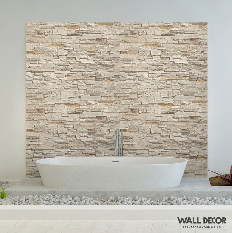 Une salle de bains moderne présente un mur d'accent en pierre Panespol™ Parement Pierre Beige - Pizarra derrière une baignoire autoportante blanche, associée à des sols blancs lisses et à un décor minimal pour une sensation de détente inspirée du spa.