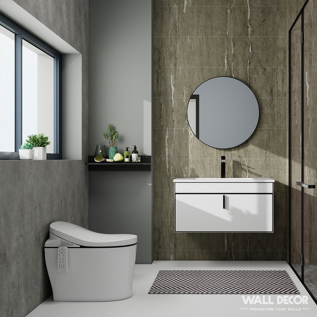 Salle de bains moderne avec un meuble-lavabo mural, un miroir rond, des toilettes blanches et une grande fenêtre. Les murs sont recouverts de Panneaux SPC Béton London de Murs 3D pour une finition semblable à la pierre ; un tapis géométrique et une étagère décorative complètent l'ensemble.