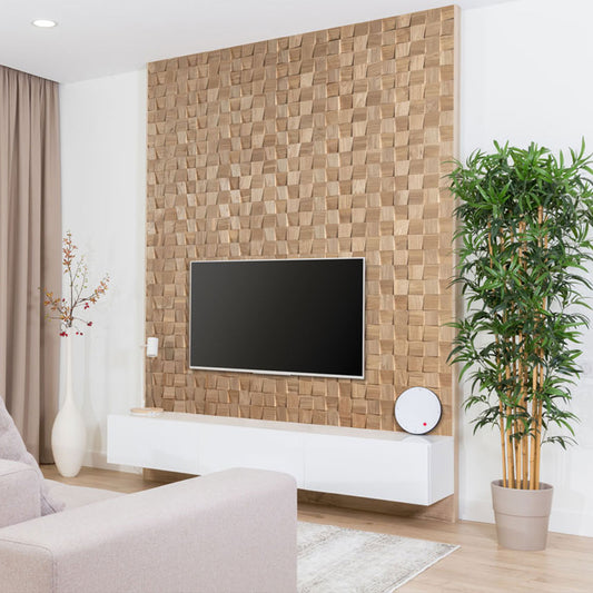 Un salon moderne présentant le Panneau mural bois Domus de Wood & Wall Decor™ comme mur d'accent en bois texturé, avec un téléviseur monté, une console blanche flottante, une plante en pot, un vase décoratif et des meubles neutres.