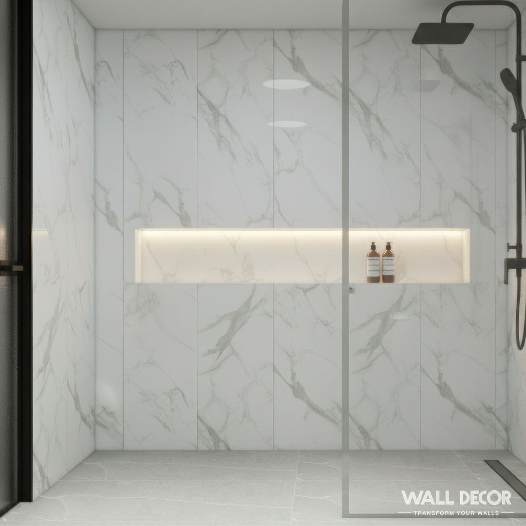 Une douche moderne avec Panneaux SPC Marbre Blanc Oslo by Murs 3D by Wall Decor, avec des panneaux muraux à effet marbre blanc, une étagère éclairée, une cloison en verre, une pomme de douche noire à effet pluie, et une marque Wall Decor subtile dans l'angle.