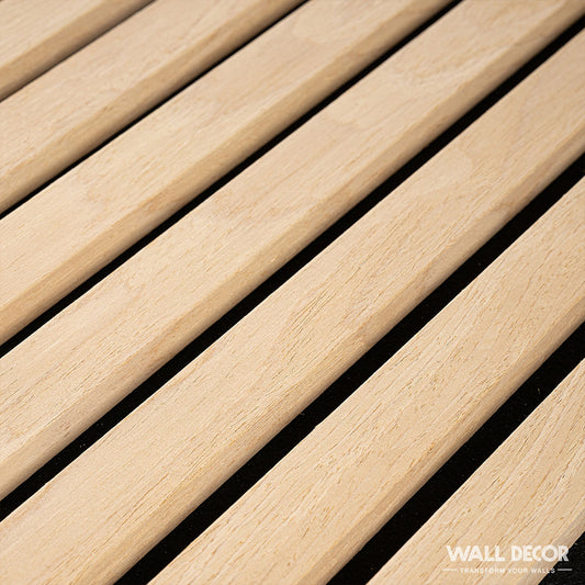 Vue rapprochée de Acoupanel™ Panneaux Tasseaux Acoustiques Chêne Clair-lames de bois acoustique en chêne clair régulièrement espacées sur fond noir. Le logo WALL DECOR apparaît dans le coin inférieur droit. Couverture : 1,28m².