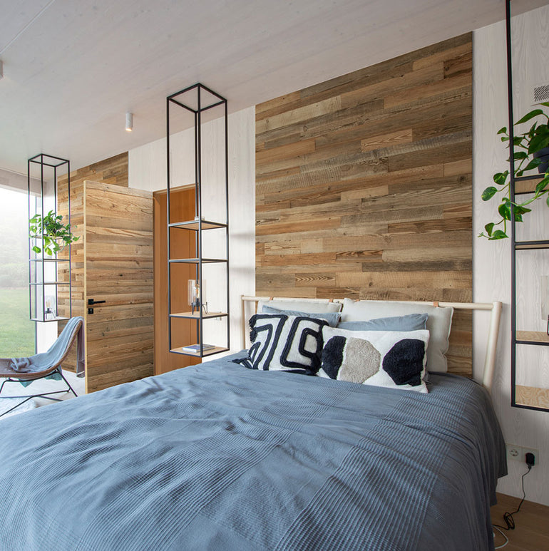 Créez une chambre à coucher moderne avec le mur d'accent en bois Parement Bois Grange de Wood & Wall Decor™-sa finition naturelle ajoute de la chaleur et du style à n'importe quel espace, s'associant magnifiquement à la literie bleue et à la décoration géométrique.