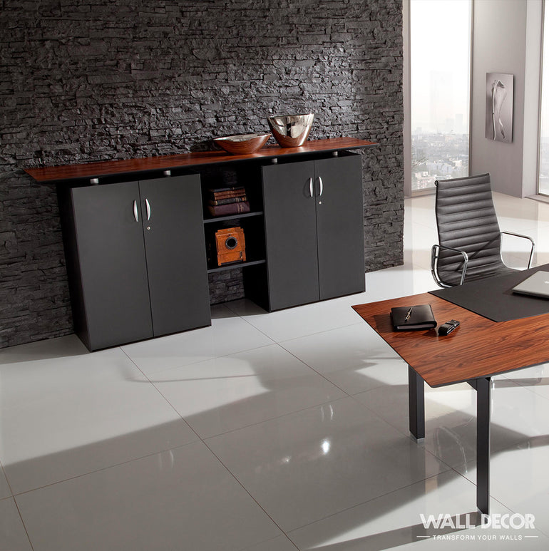 Bureau moderne comprenant un mur d'accent Plaque Pierre Noire mate - Laja (2,85m x 1,3m) de Covering Panels™, des armoires noires épurées, un comptoir et un bureau en bois, un bol en métal, des étagères en bois avec décor, une chaise noire, et un sol en carrelage blanc brillant.