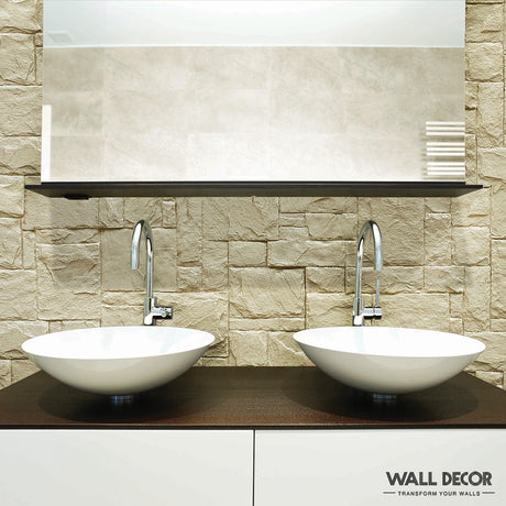 Salle de bain moderne avec deux vasques blanches, des robinets chromés, un comptoir sombre et un mur Plaque Pierre crème - Style Travertin (2,85m x 1,3m) par Covering Panels™. Un grand miroir est fixé au-dessus des lavabos. Marque visible dans le coin inférieur droit.