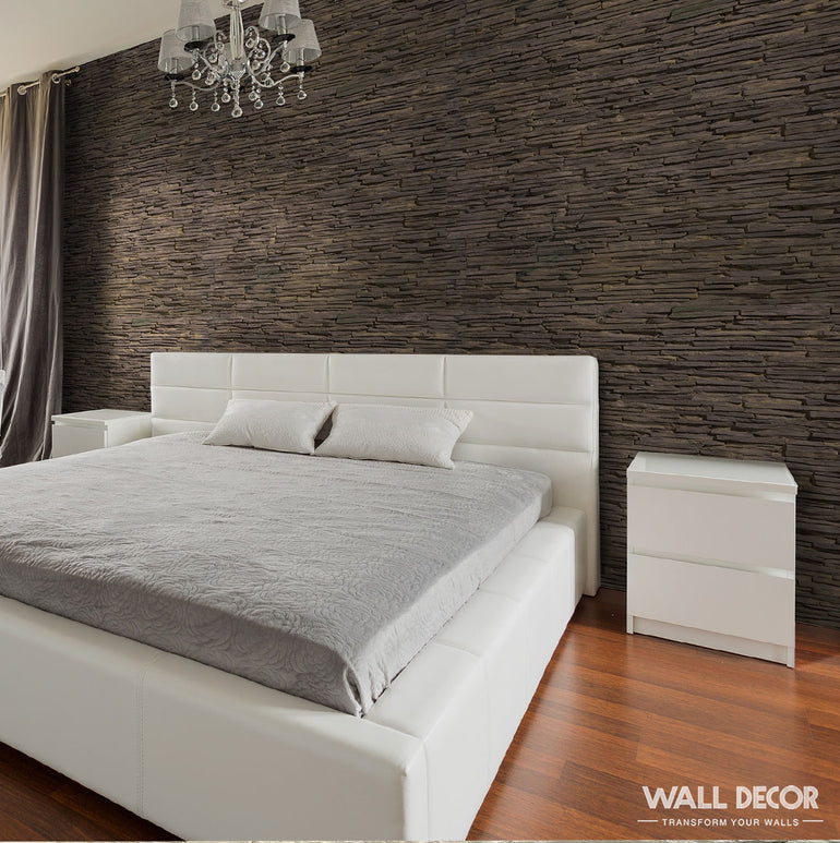 Chambre à coucher moderne avec un lit capitonné blanc, une literie grise et deux tables de nuit blanches dans une disposition flexbox de style table. Un lustre est suspendu au-dessus de planchers en bois et d'un mur d'accent Parement Pierre noire - Laja Fina de Panespol™. La lumière du soleil filtre à travers les rideaux de gauche.