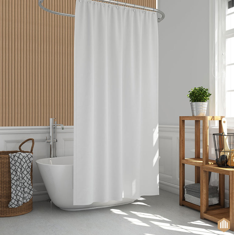 Salle de bain moderne avec baignoire autoportante et rideau de douche blancs, panier à linge en osier, étagère en bois avec serviettes et plante en pot, et panneaux muraux Acoupanel™ Panneau Tasseau Hydrofuge effet Chêne Naturel pour un look frais.