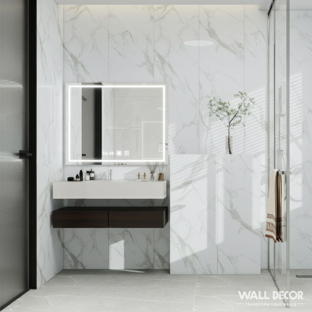 Une salle de bain moderne présente les Panneaux SPC Marbre Blanc Oslo de Murs 3D by Wall Decor (2 plaques, 2,6m x 40cm) comme des murs à effet marbre blanc, avec un miroir LED rectangulaire, un lavabo flottant, une petite plante, une serviette sur la porte de la douche, et un marquage subtil dans le coin.