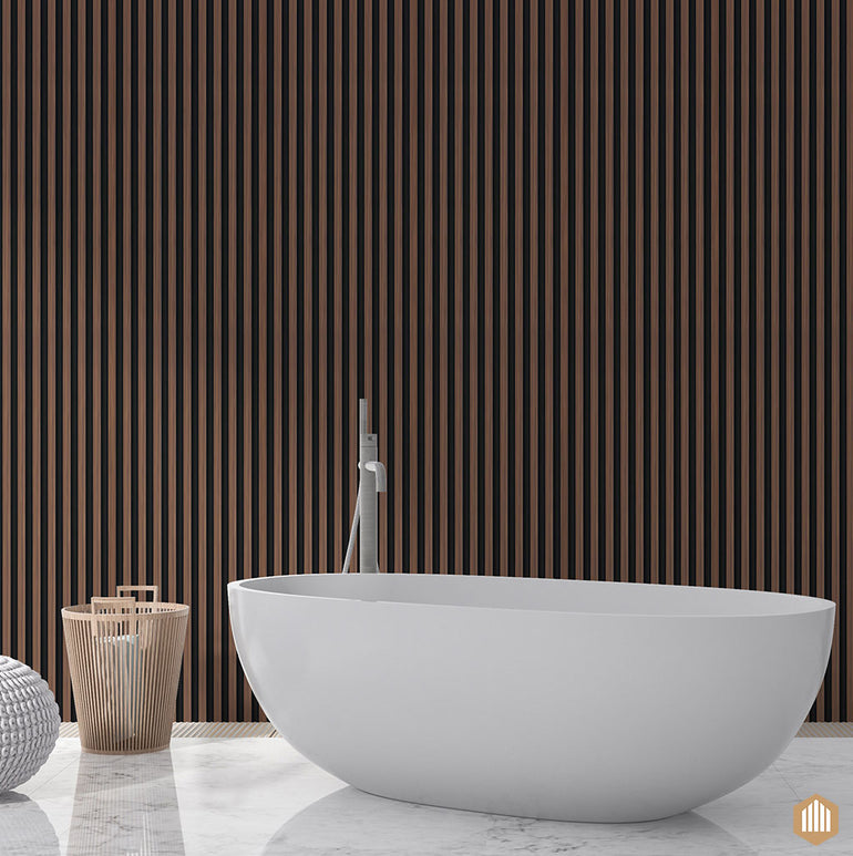 Une salle de bain moderne avec une baignoire autoportante ovale blanche, un Acoupanel™ Panneau Tasseau Hydrofuge effet Chêne Brun - Fond noir en lattes, un panier à linge en bois et un tabouret texturé blanc sur un sol en marbre.