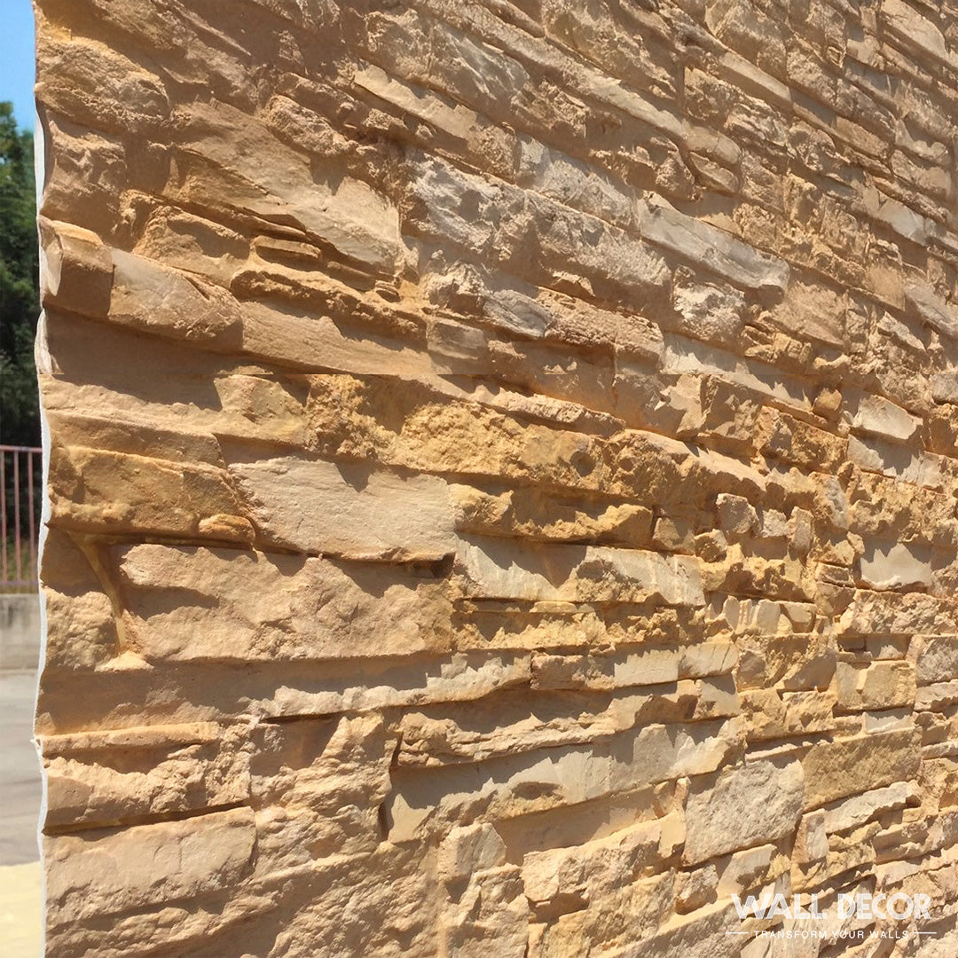 Un gros plan de la Plaque Pierre Ocre - Laja (2,85m x 1,3m) de Covering Panels™, montrant des textures de pierre tan et beige empilées et irrégulières avec des couches rugueuses et des rainures profondes, éclairées par la lumière du soleil.