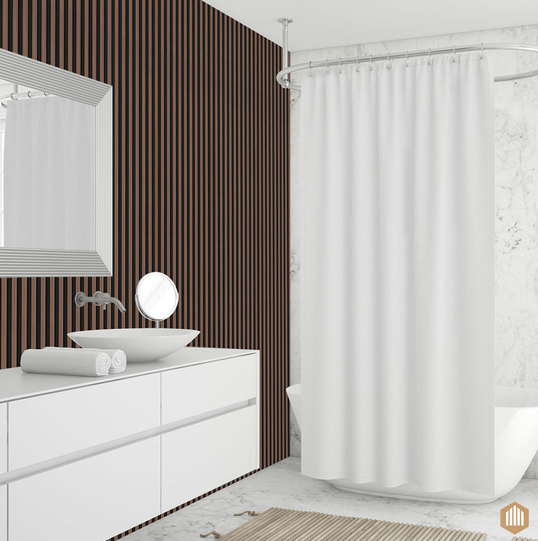 Salle de bain moderne avec un meuble-lavabo blanc, un évier à vasque, un miroir rond et un rideau de douche blanc sur une tringle incurvée. Le mur est doté d'Acoupanel™ Panneau Tasseau Hydrofuge effet Chêne Brun - Fond noir pour un style texturé. Le sol en marbre blanc ajoute de l'élégance.